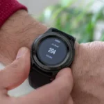 person wearing round black smartwatch